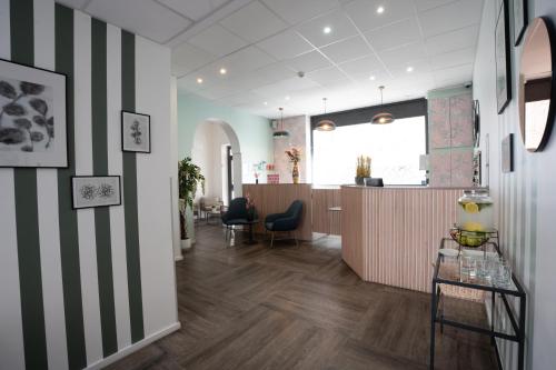 ein Büro mit einer gestreiften Akzentwand und einer Lobby in der Unterkunft Hôtel Alcôve Nice in Nizza