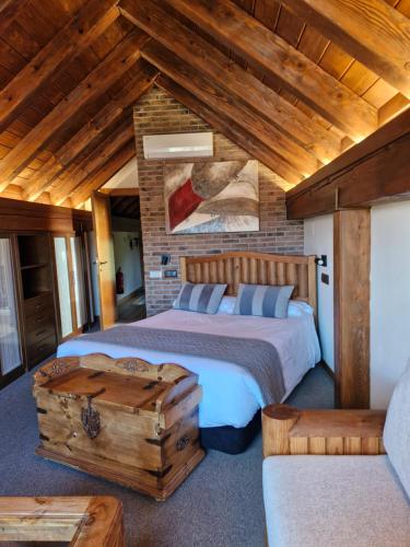 a bedroom with two beds and a wooden ceiling at Hotel Rural Irati selva de Irati in Jaurrieta