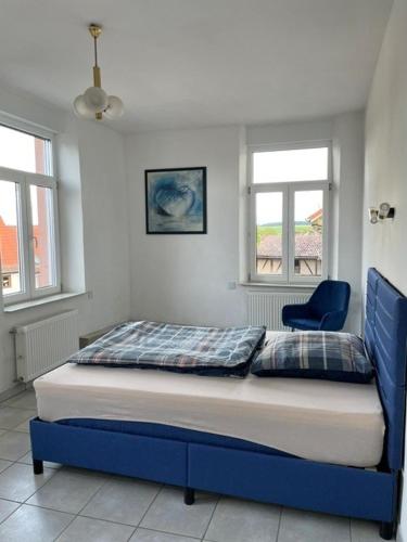 a bed with a blue frame in a bedroom at Monteurunterkunft in Brombachtal
