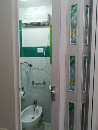 ein Badezimmer mit Waschbecken, Toilette und Spiegel in der Unterkunft Jemi's House in Vibonati