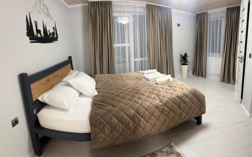 a bedroom with a bed and a large window at Vista Guest House in Yaremche