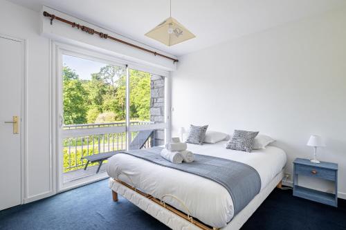 a bedroom with a bed and a large window at L'Instant Arradon - Pointe & sentiers côtiers in Arradon