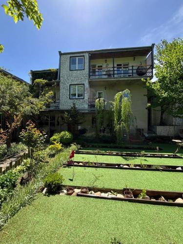 a house with a garden in front of it at Shin Boutique Hotel with Mini Golf Terrace in Buriaki