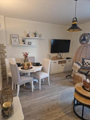 a living room with a table and chairs and a tv at PIK-KWATERY in Olsztyn