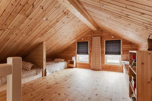 a large attic room with a bed and two windows at Tännstoppet - Tänndalen in Tänndalen