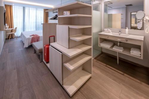 a bathroom with a sink and a bed and a mirror at GHT Sa Riera in Tossa de Mar