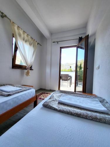 two beds in a room with a view of a patio at Pansion & Apartments MOST Blagaj in Blagaj