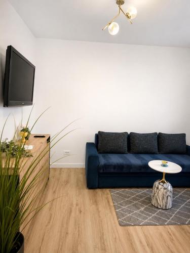a living room with a blue couch and a table at Sfara Residence Apartament 6 in Baia Mare