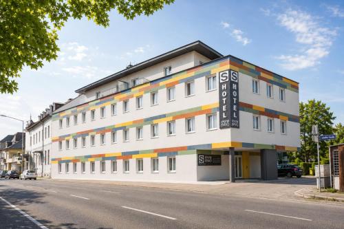 a white building with a colorful facade on a street at SHOME Hotel Graz I Self-Check-In I Free Parking in Graz