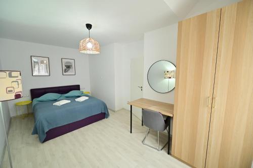 a bedroom with a bed and a desk and a mirror at FLH - Brukenthal Studios - Old Town in Sibiu
