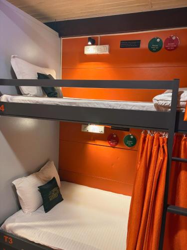 a bunk bed in a room with an orange curtain at Forrest Hostels in Mumbai