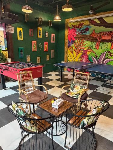 a ping pong room with ping pong tables and a mural at Forrest Hostels in Mumbai