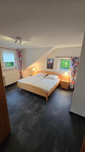a bedroom with a large bed and two windows at Ferienhaus am Alten Kloster in Lorch am Rhein