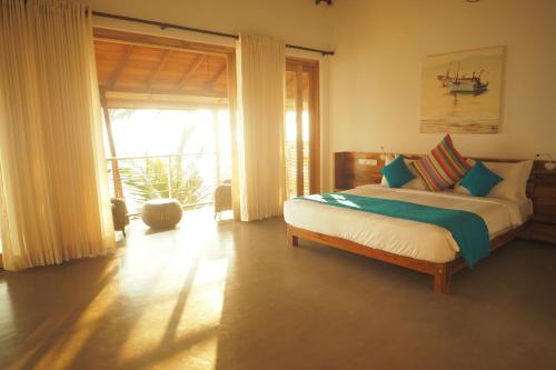a bedroom with a bed and a large window at The Seascape in Matara