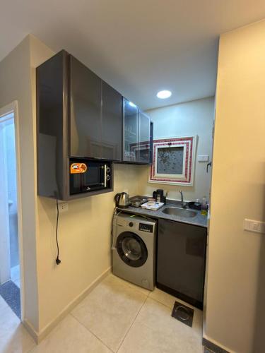 a small kitchen with a washing machine and a sink at شقة فندقية غرفة واحدة in Mansoura