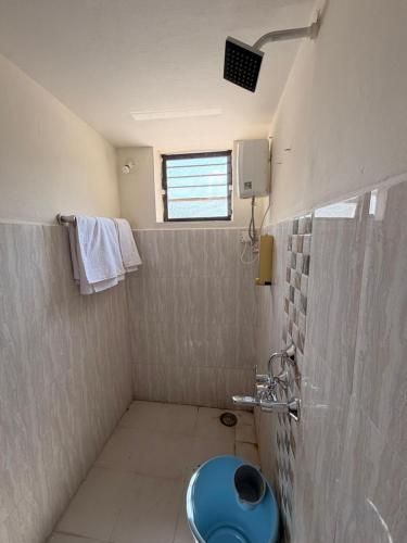 a bathroom with a blue toilet and a window at Swami Homestay in Solapur