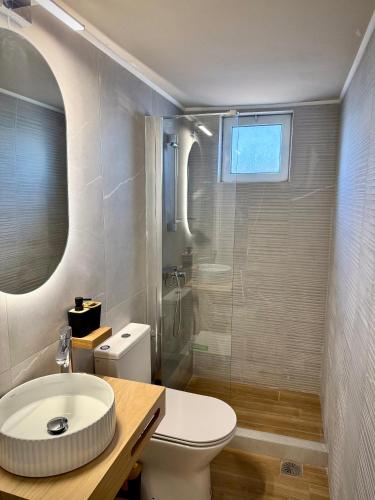 a bathroom with a toilet and a sink and a shower at Vstay Residence 2 - near Airport & Beach in Artemida