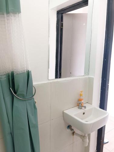 a bathroom with a sink and a mirror at Starla Apartment in Kinoo