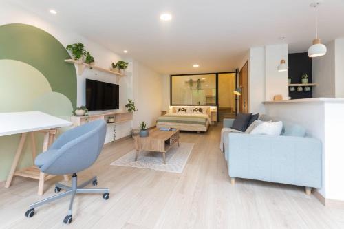 a living room with a couch and a bed at Amaru Suites Salento - Apartamentos con Jacuzzi y Vistas al Bosque in Salento