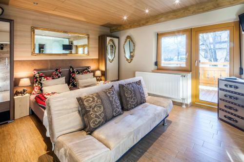 a living room with a couch and a mirror at Gasthaus-Pension Reiterklause in Leutasch