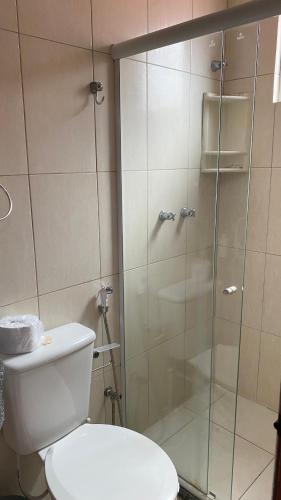 a bathroom with a toilet and a glass shower at RioVermelhopoint in Salvador
