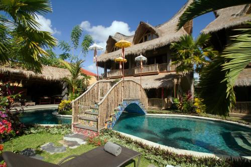 a resort with a bridge over a swimming pool at Bali Bohemia Huts in Ubud