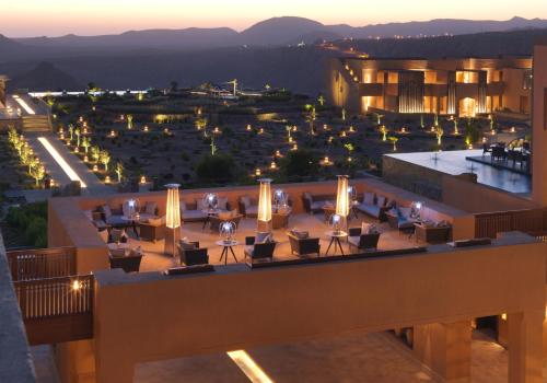 a view of a building with tables and chairs at Anantara Al Jabal Al Akhdar Resort in Al ‘Aqar