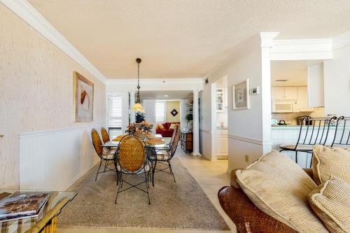 a living room with a table and a kitchen at Sea Colony oceanfront 4th floor condo with elevator in Bethany Beach