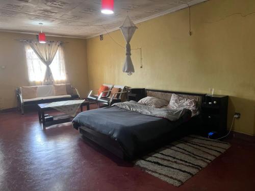 a bedroom with a bed and a couch in a room at PODLYNS Home in Ngong