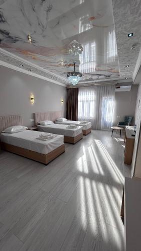 a large room with two beds and a table at Velora Hostel in Khiva