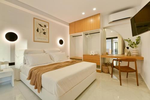 a white bedroom with a bed and a desk at Sole Azzurro Villas in Kanali