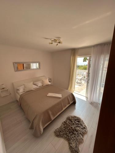 a bedroom with a large bed and a window at Apartments Neda in Primošten