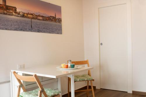 a white table and chairs in a room with a painting on the wall at Casetta don Bosco in Chioggia
