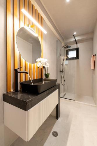 a bathroom with a black sink and a mirror at Sole Azzurro Villas in Kanali