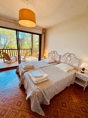 a bedroom with two beds and a balcony at Duplex T3 2 étoiles bord de lac 65mcarrés in Biscarrosse