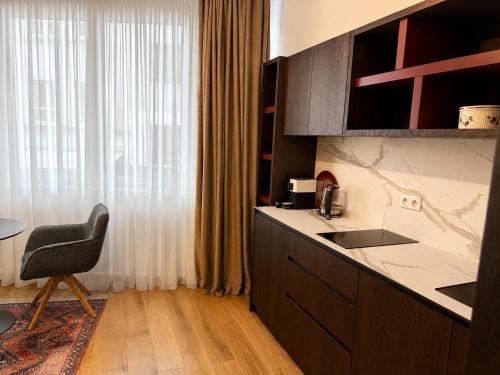 a kitchen with a sink and a chair next to a window at Design-Apartment Siegen Oberstadt in Siegen