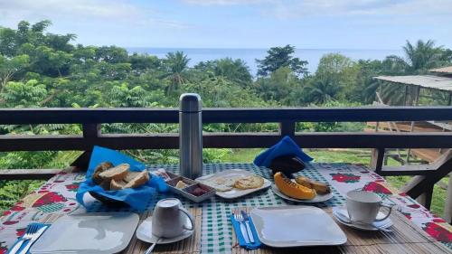 a picnic table with food and a view of the ocean at Roça Monte Forte in Neves