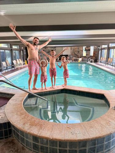 a man and two children standing in a swimming pool at Shanty Creek, Golf, Families, Vacation, Pool Pass in Bellaire