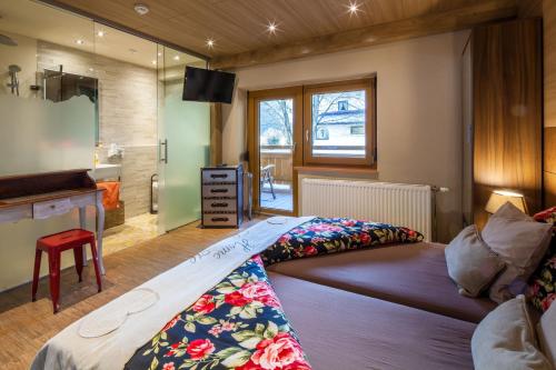 a bedroom with a bed and a television in a room at Gasthaus-Pension Reiterklause in Leutasch