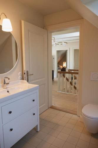 a bathroom with a white sink and a toilet at JETHON Appartement am Wasserturm 1 in Nienburg