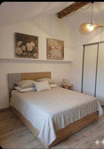 a bedroom with a bed and two paintings on the wall at Maison Milani Centuri in Centuri