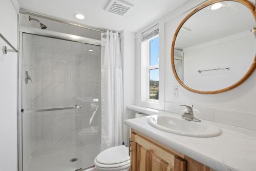 a bathroom with a shower and a sink and a mirror at Huckleberry Inn in Custer