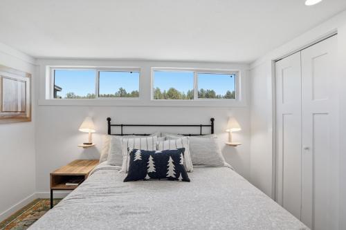 a bedroom with a large bed with two windows at Huckleberry Inn in Custer
