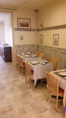 a dining room with tables and chairs in a room at Hotel Queen Mary in Brussels