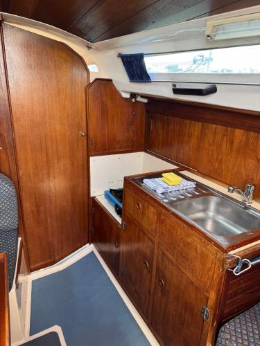 a kitchen with wooden cabinets and a sink in a boat at Schlafplatz mit Meerblick in Kühlungsborn