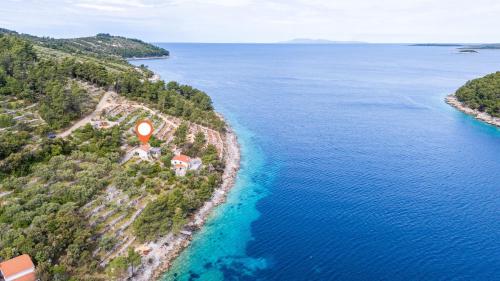 an island with a house on the shore of the water at House Vers in Vela Luka