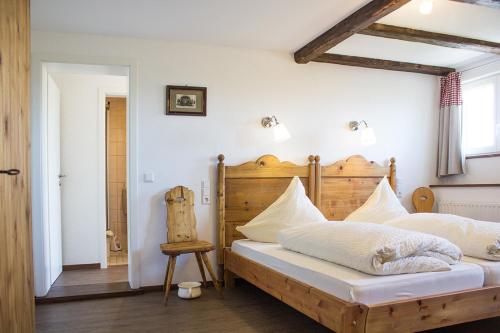 a bedroom with a bed with a wooden headboard at Pension Kramer in Grafenhausen