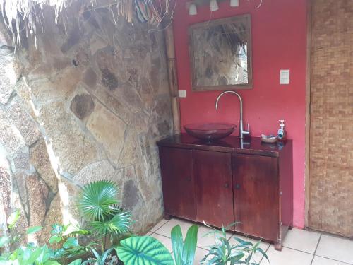 a bathroom with a sink and a red wall at San Simian Lodge in La Laguna