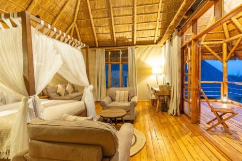 a bedroom with a bed and a living room at Kidepo Wilderness Lodge in Loitanit