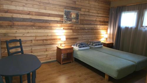 a bedroom with a bed and a wooden wall at Viitna Puhkekeskus in Viitna